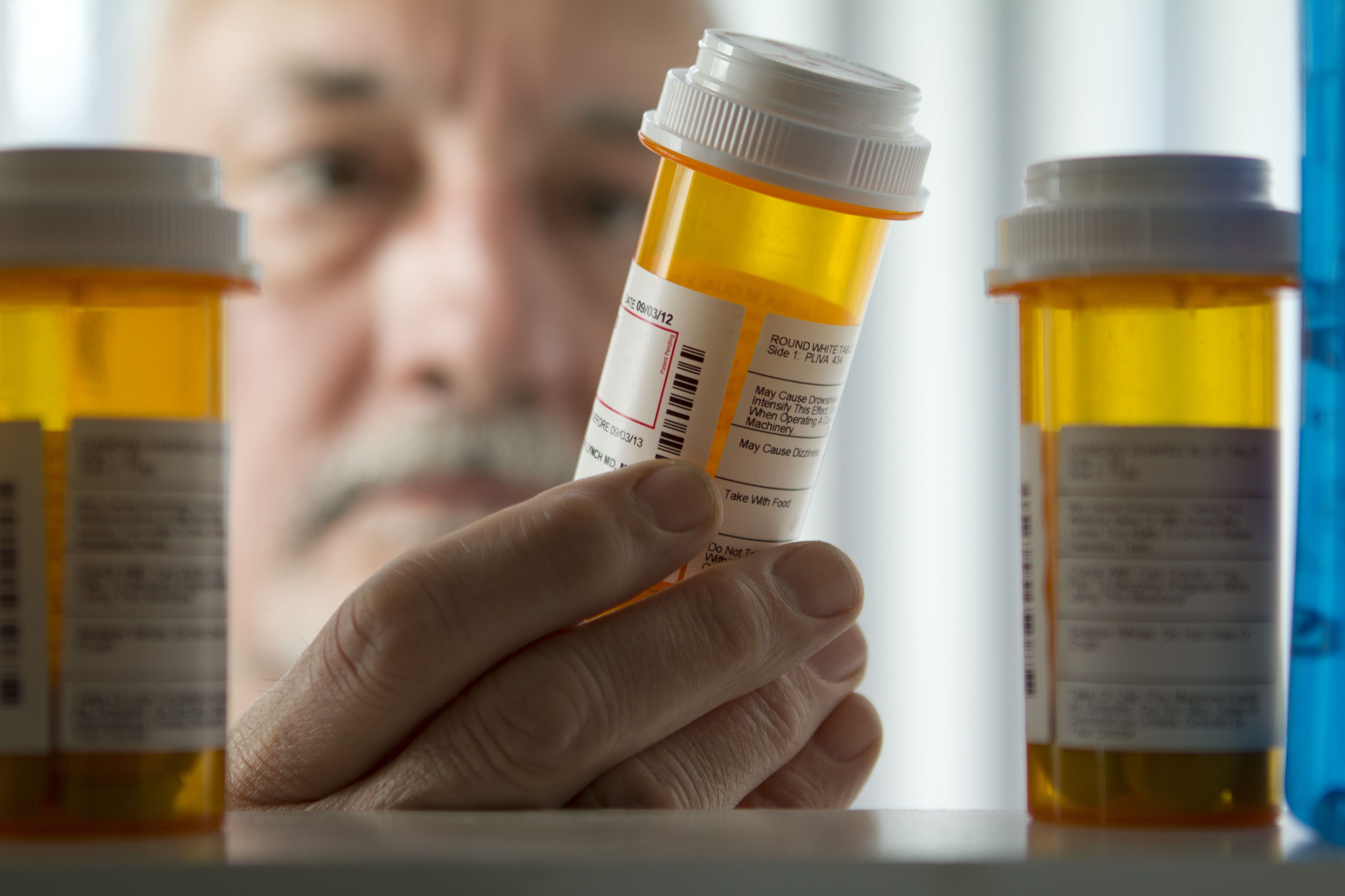 Man looking in medicine cabinet for What Medicines to Keep in your house blog post - Genesis Healthcare SC